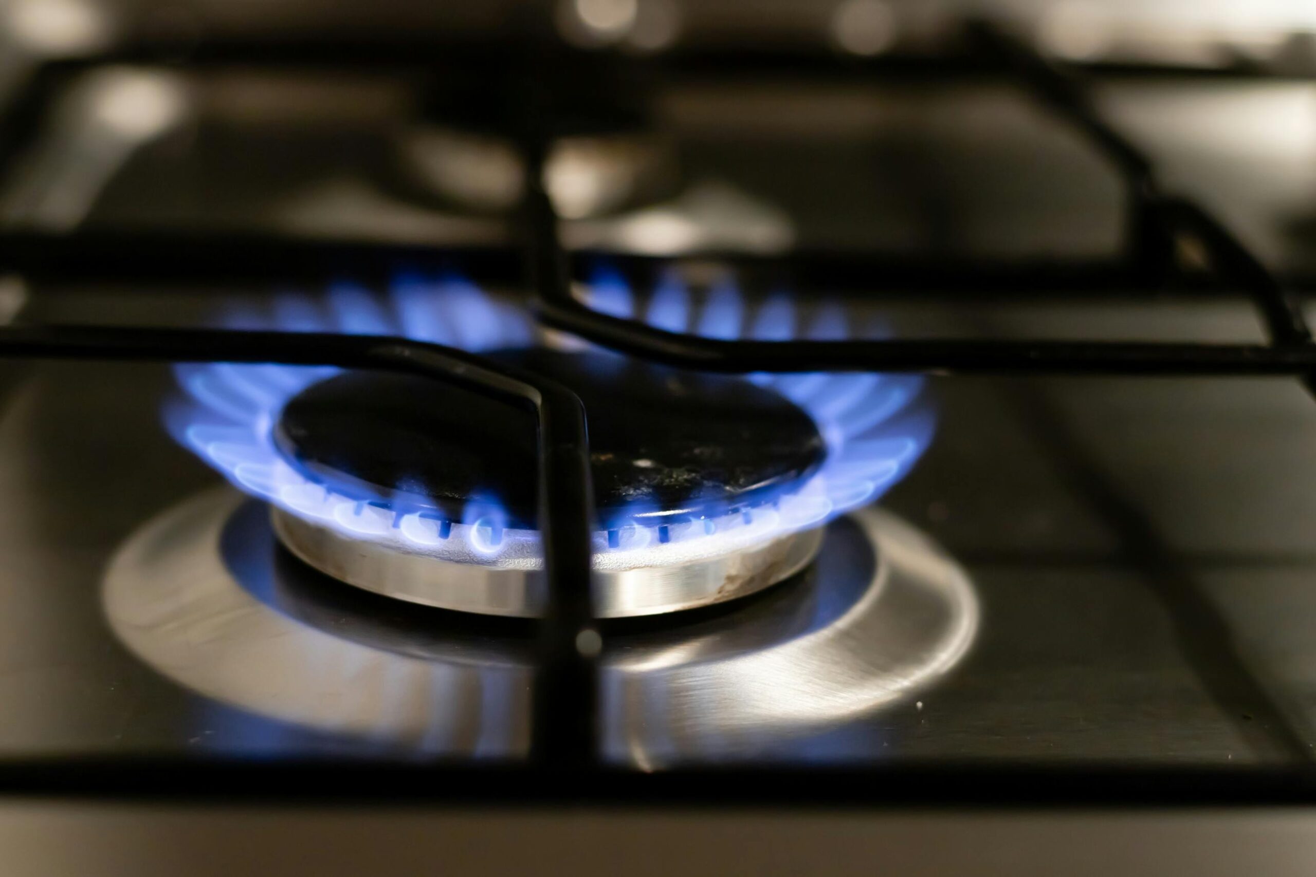 Главная страница A detailed view of a blue flame on a stove, showcasing energy and heat.