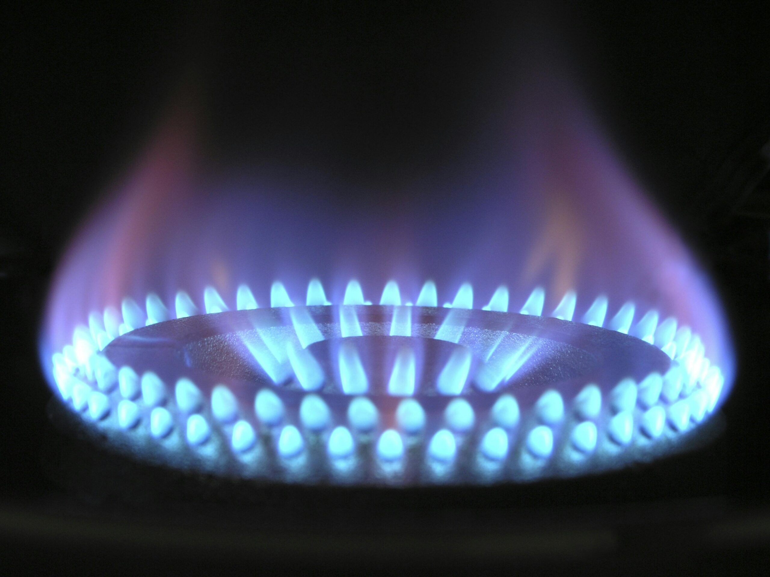 Главная страница A detailed view of a blue flame on a gas stove, illustrating heat and warmth.